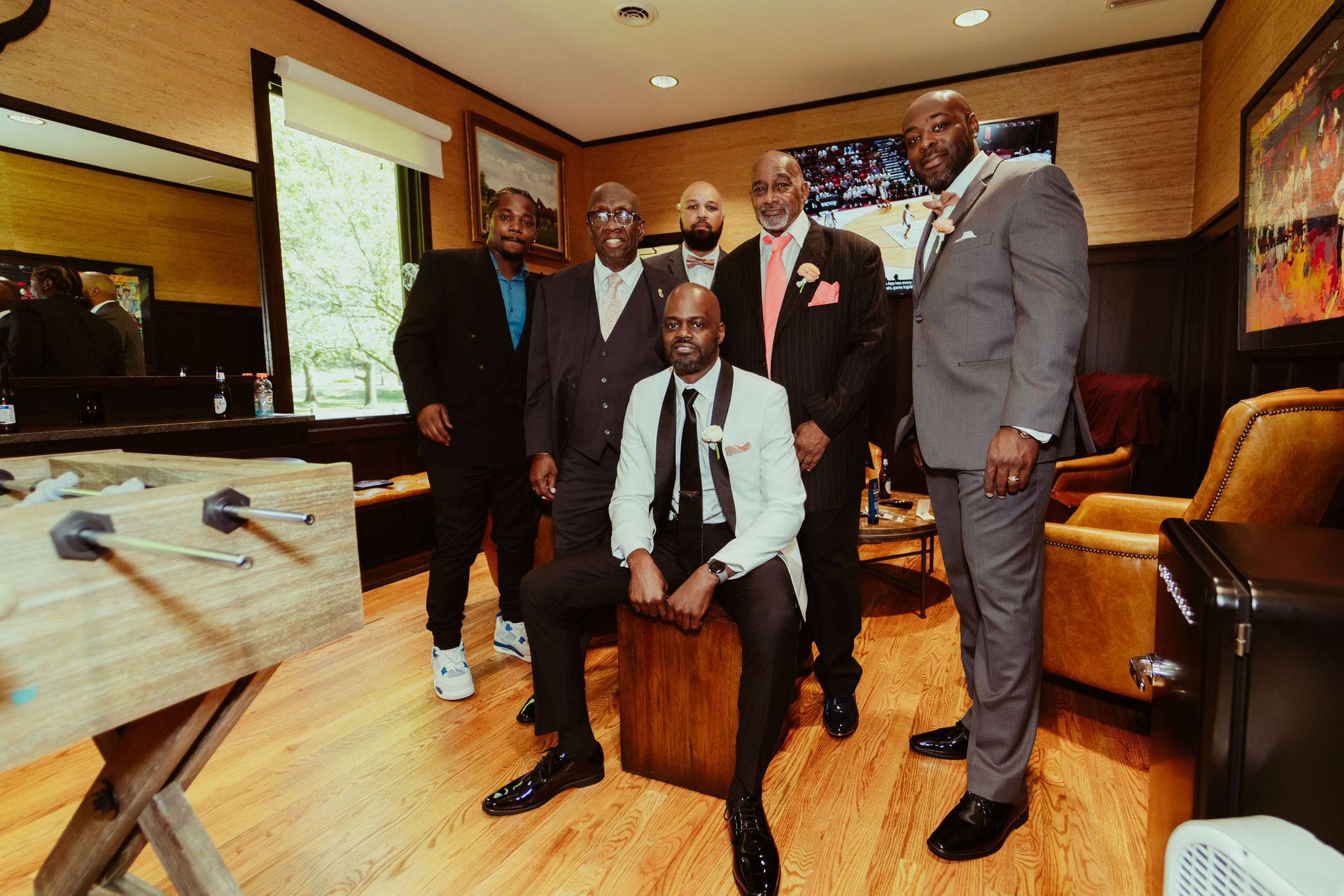 A group of men in suits are posing for a picture in a living room.