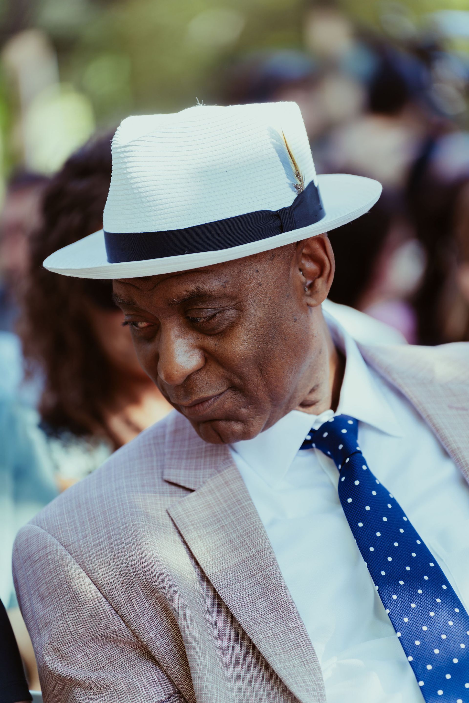 A man wearing a white hat and a blue tie