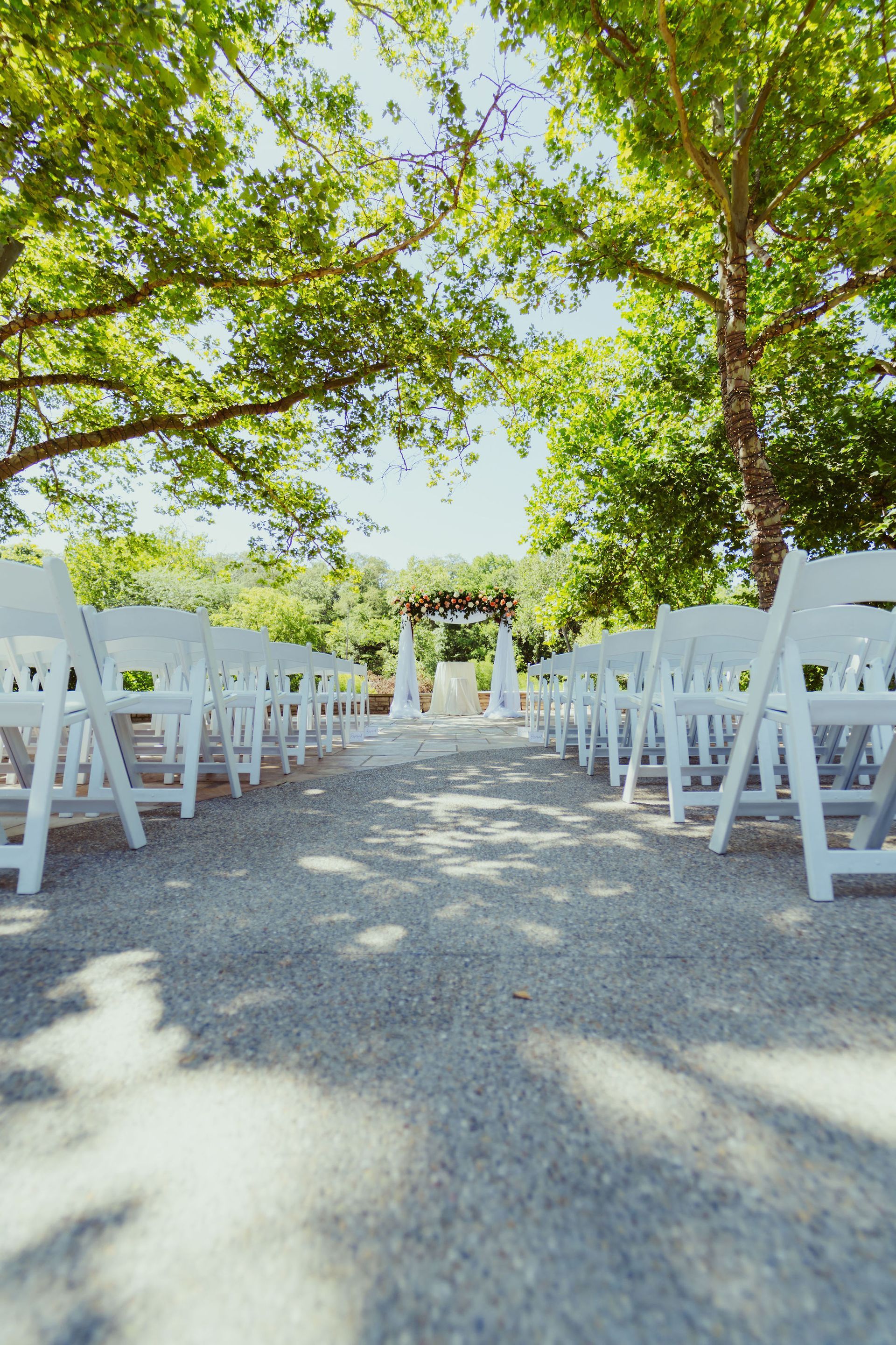 A row of white folding chairs are lined up in a row.