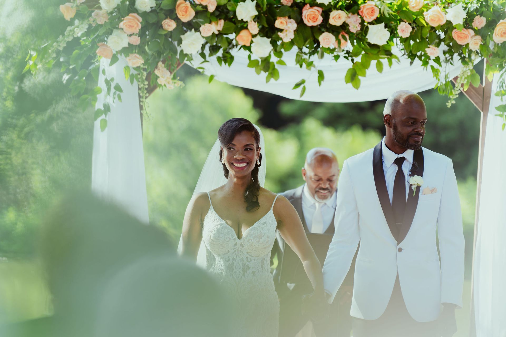 A bride and groom are walking down the aisle at their wedding holding hands.