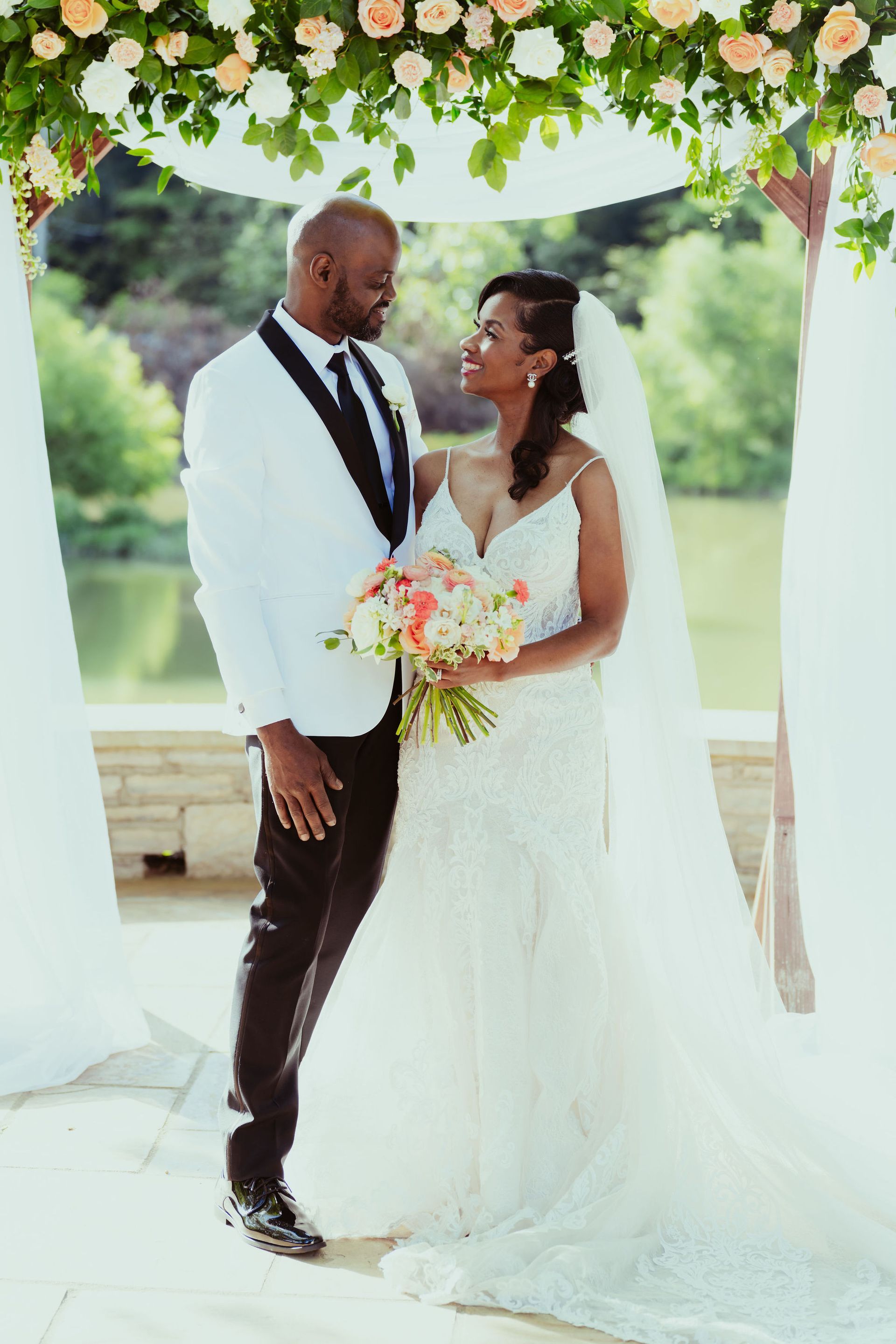 A bride and groom are posing for a picture at their wedding.