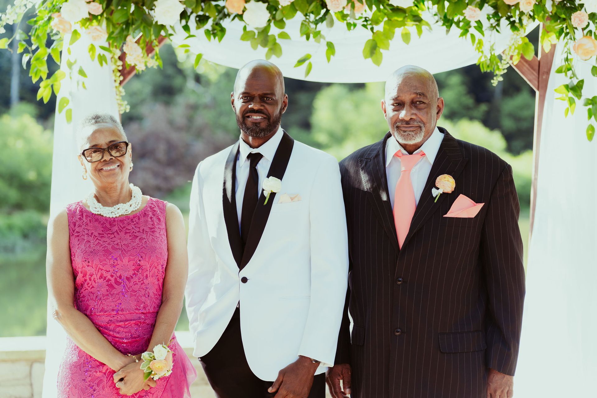 A bride and groom are posing for a picture with their parents at their wedding.