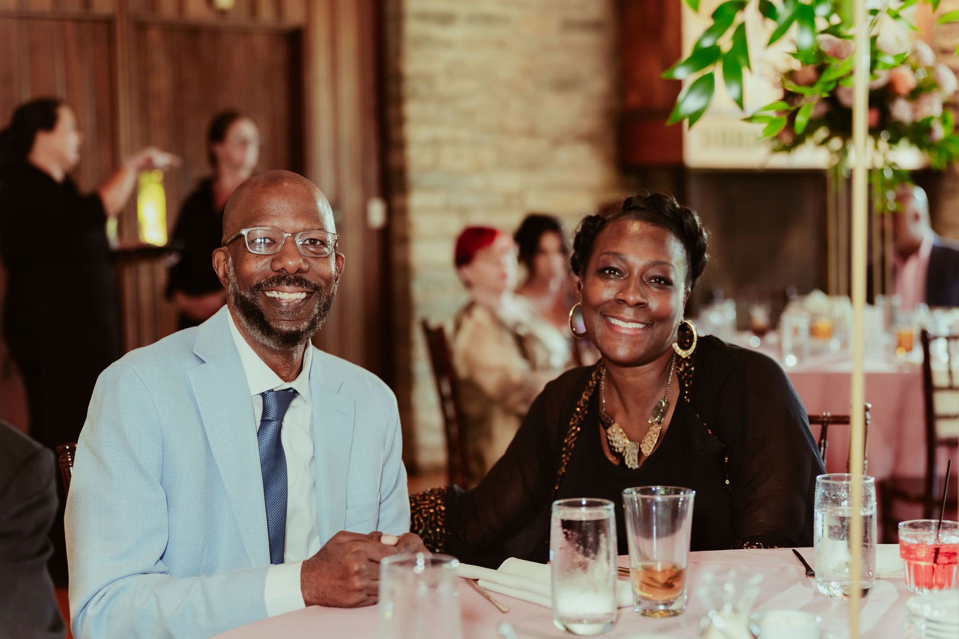 A man and a woman are sitting at a table at a wedding reception.