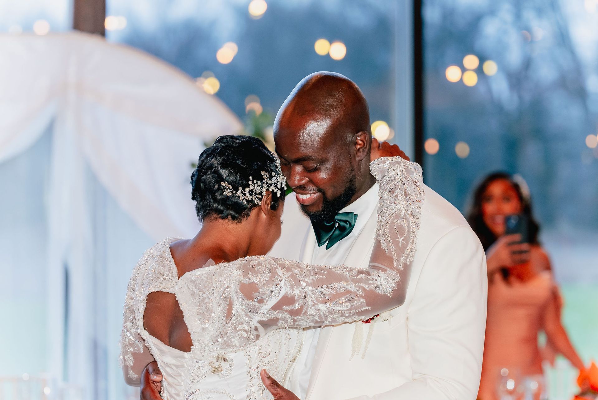 A bride and groom are dancing together at their wedding reception.