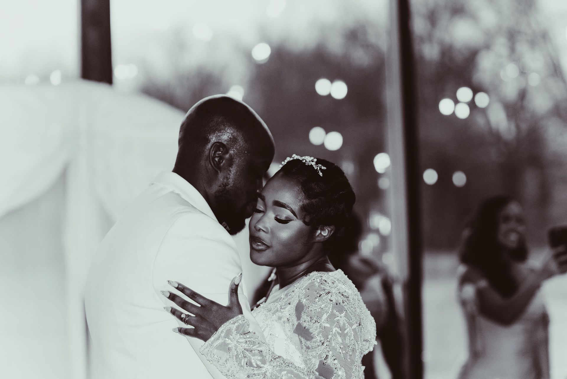 A black and white photo of a bride and groom dancing at their wedding reception.