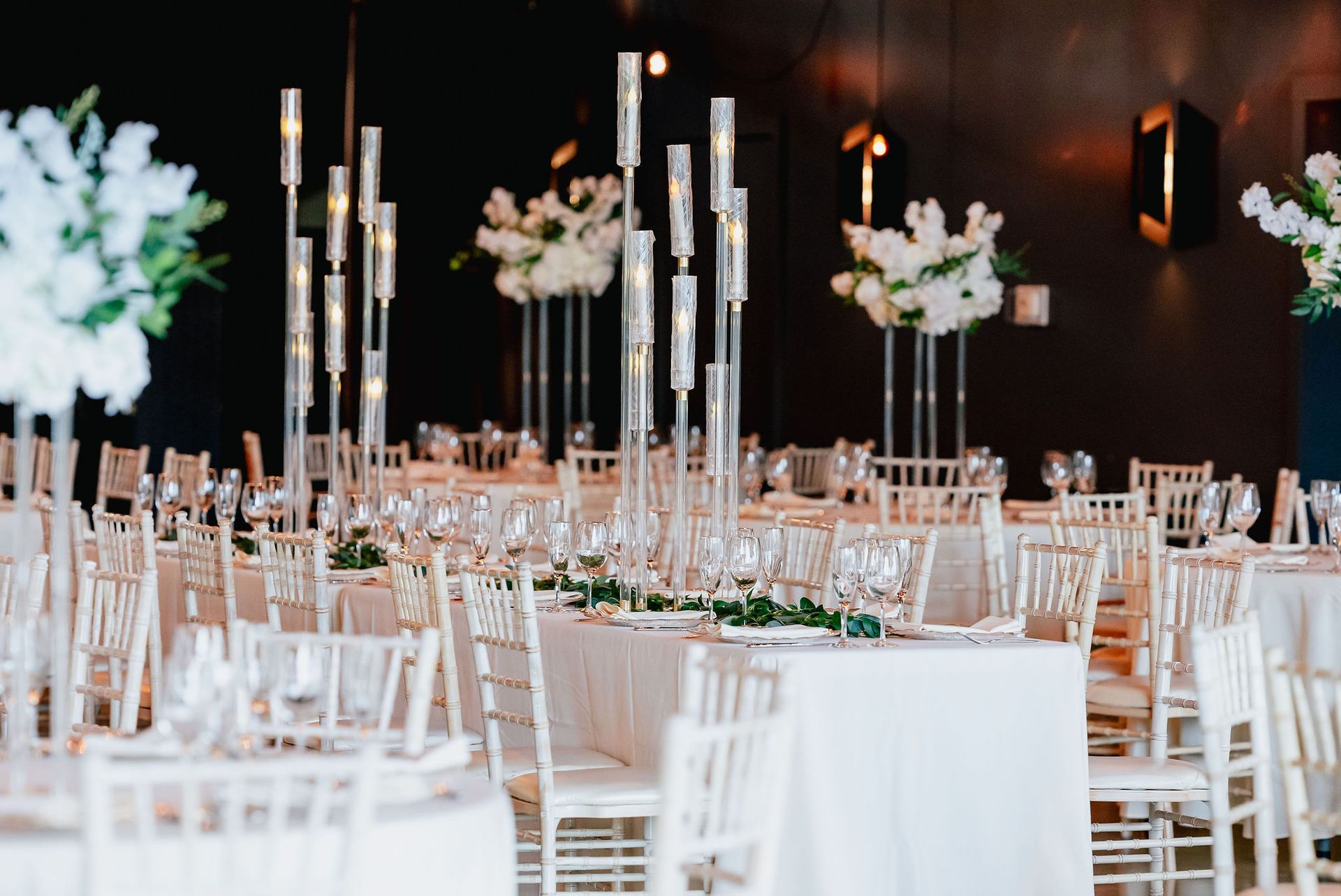 A large room with tables and chairs set up for a wedding reception.