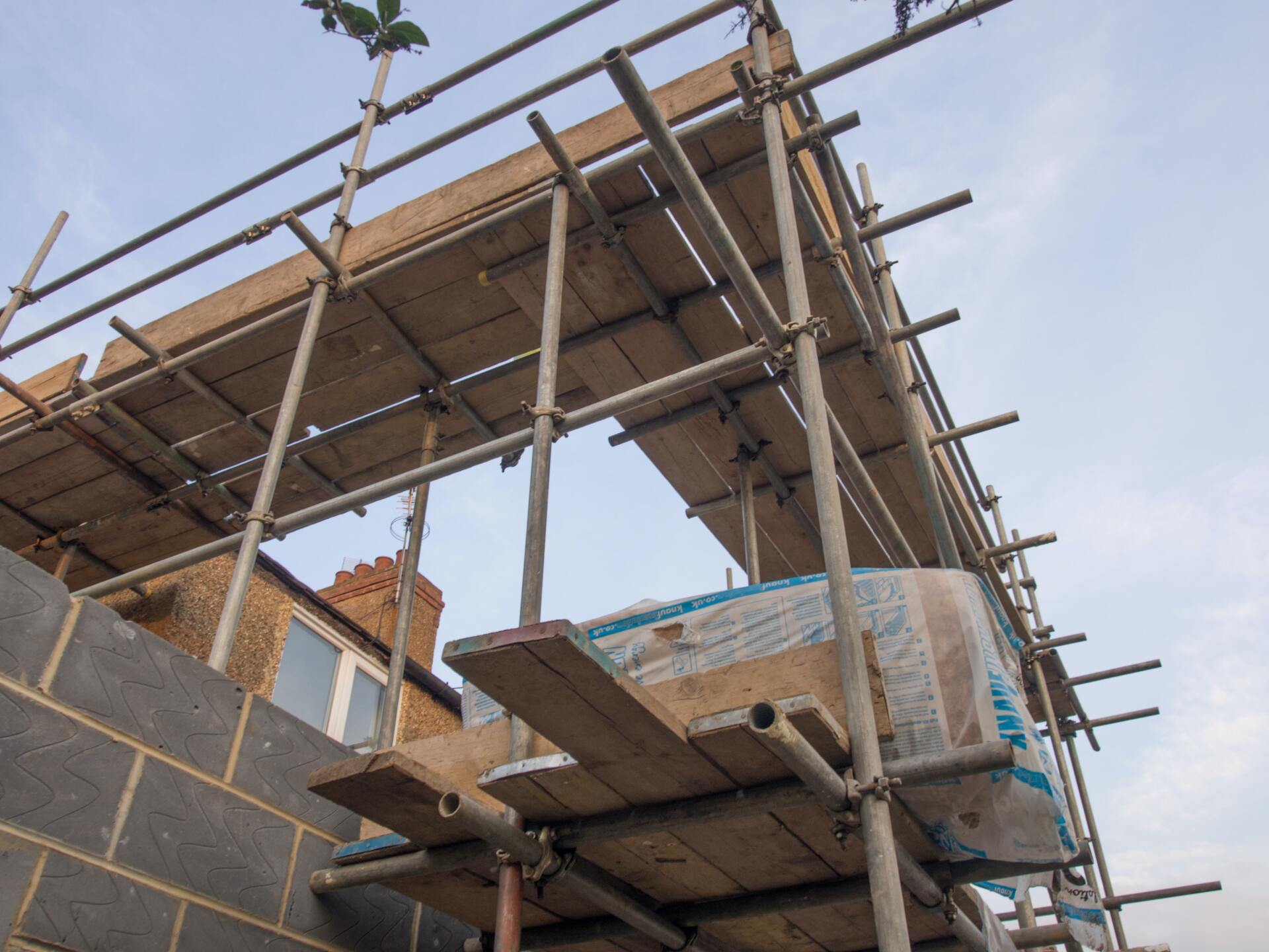 A scaffolding structure is being built on top of a brick building.