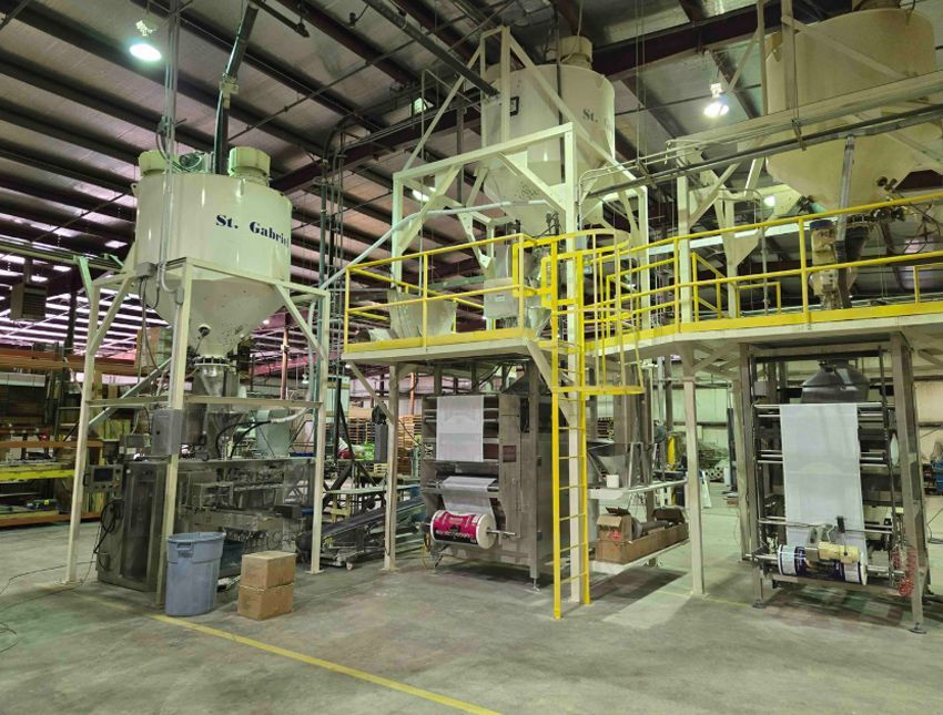 A factory with a lot of machinery and a yellow railing.