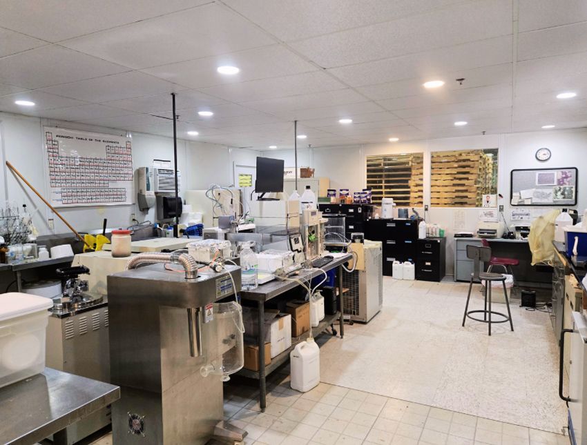 A kitchen with a lot of stainless steel appliances and a clock on the wall.