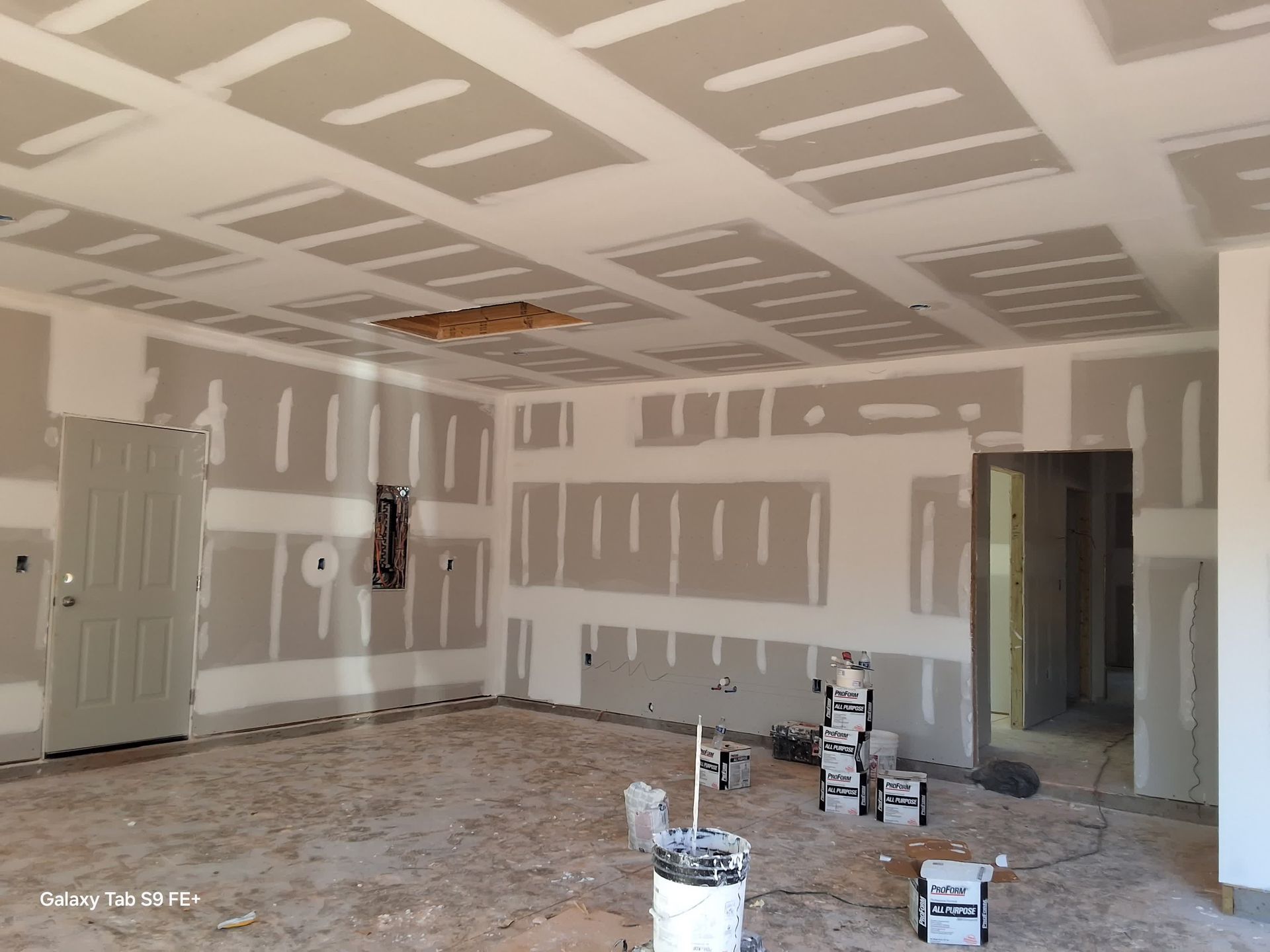 a kitchen under construction with stainless steel appliances and gray cabinets .