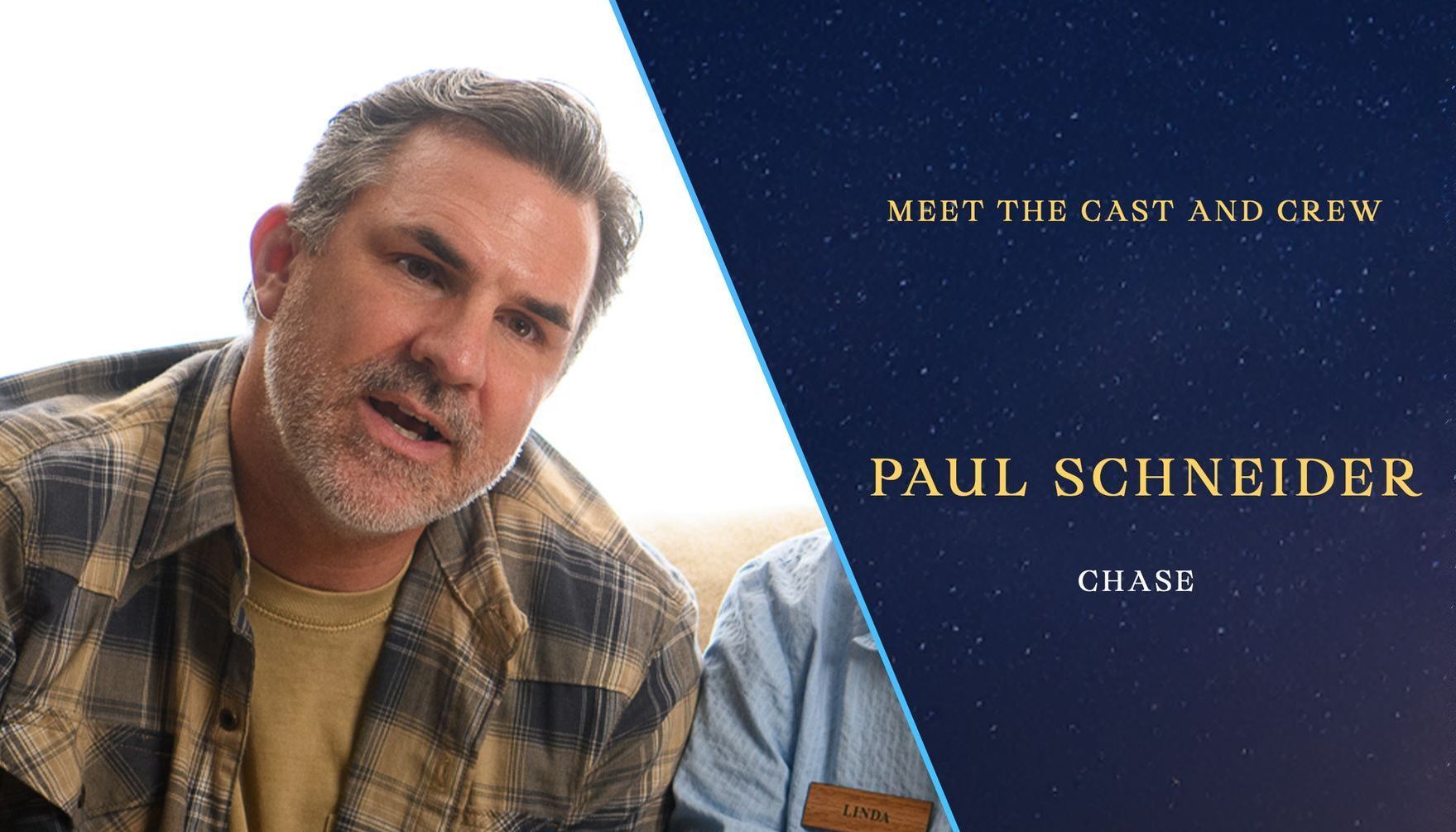 A man in a plaid shirt is sitting on a couch.