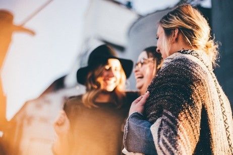 A group of women are standing next to each other and laughing.