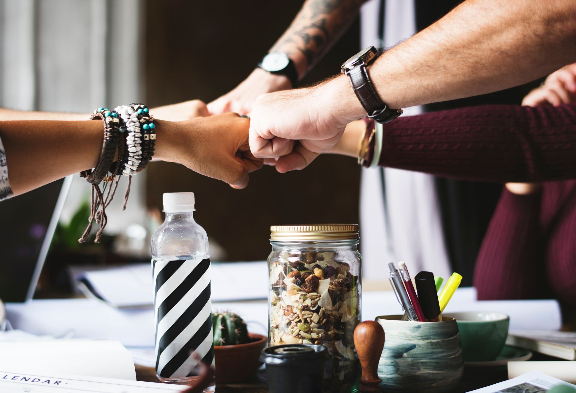 A group of people are putting their hands together