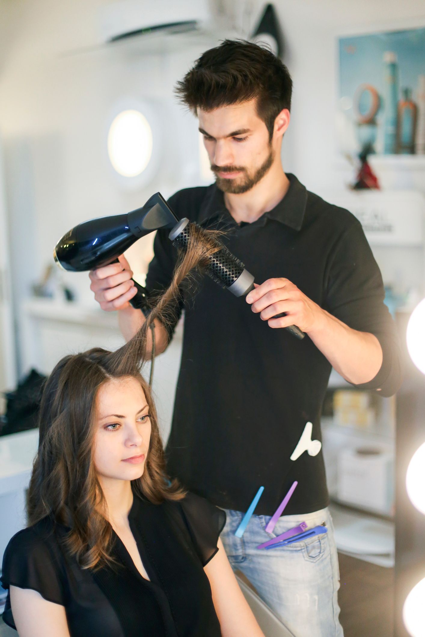 Un uomo sta asciugando i capelli di una donna in un salone.