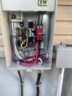 A electrical box with a lot of wires coming out of it.