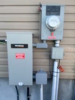 A generator is attached to the side of a house