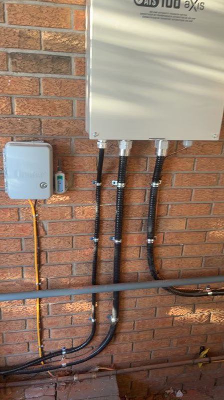 A brick wall with a box and wires attached to it.