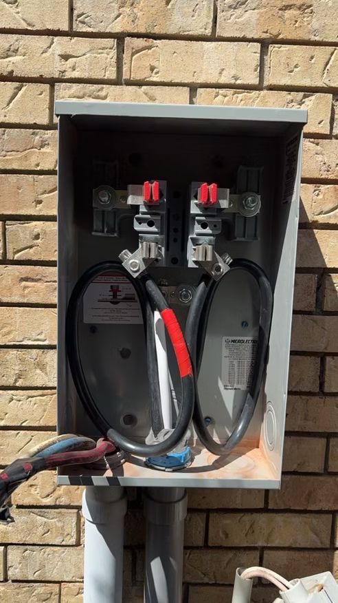 A close up of a electrical box on a brick wall.