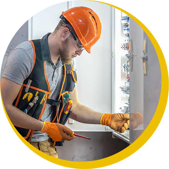 A man wearing a hard hat and gloves is working on a wall.