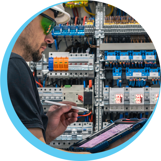 A man wearing a hard hat is looking at a tablet