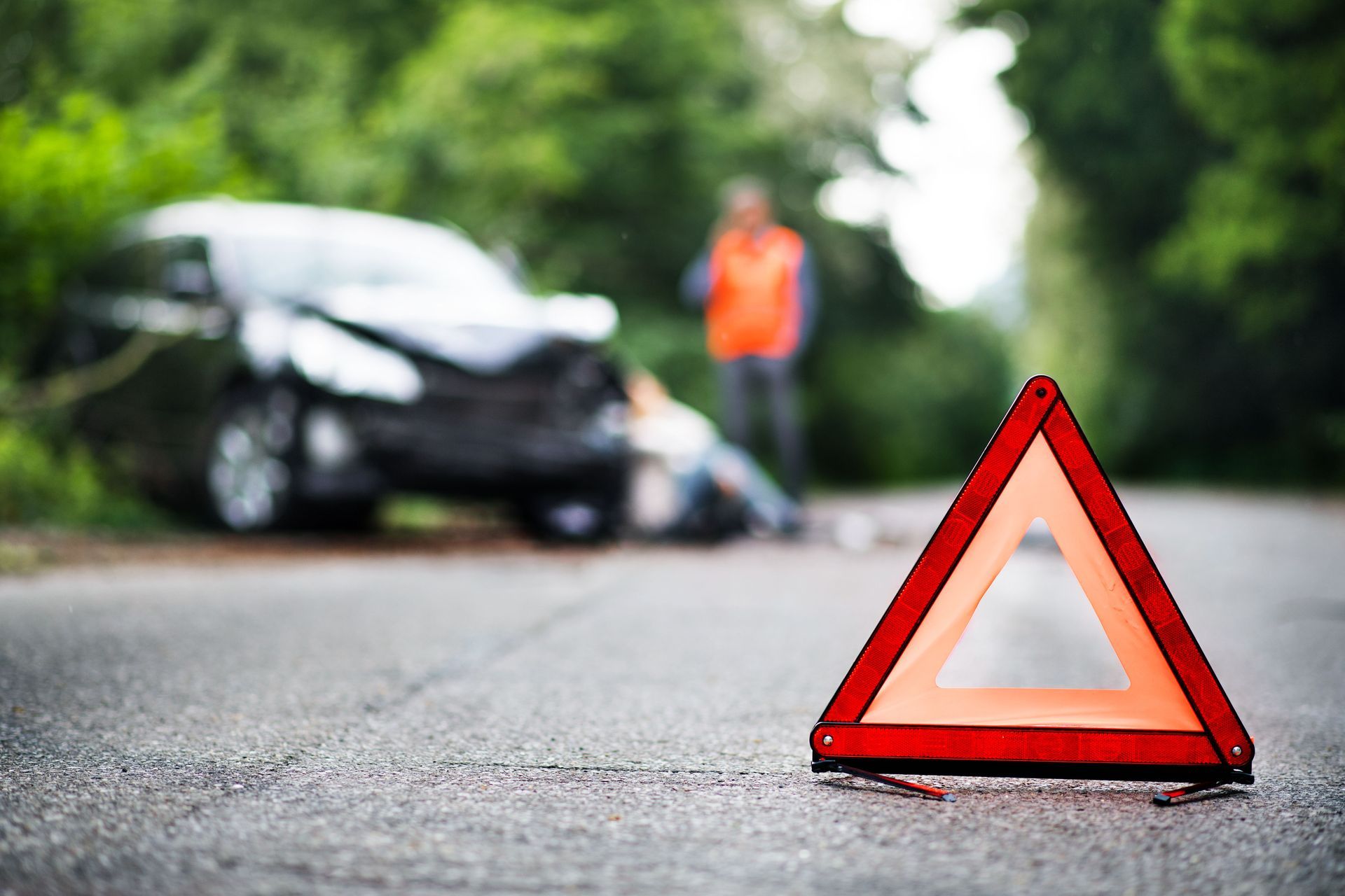 A car accident with a warning triangle on the side of the road.