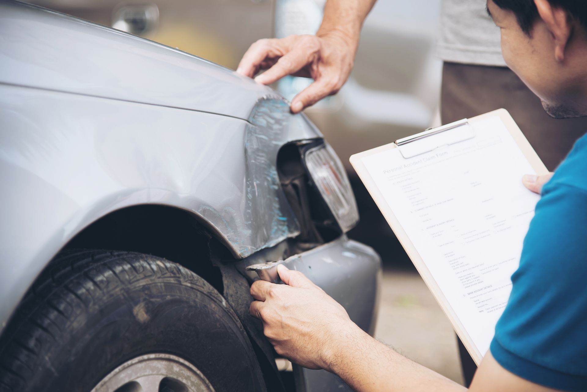 a man is looking at a car with a clipboard .