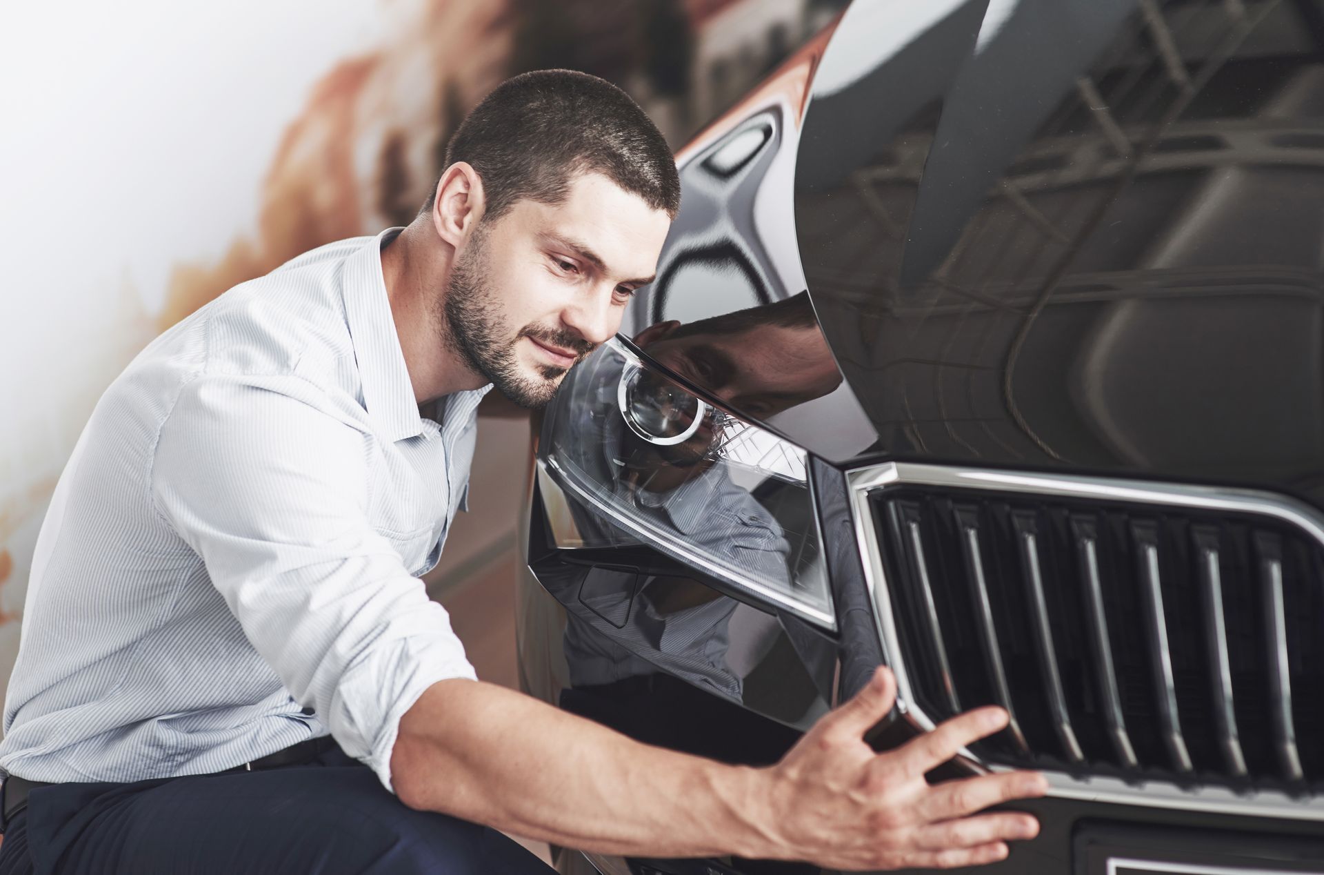 a man is looking under the hood of a car .