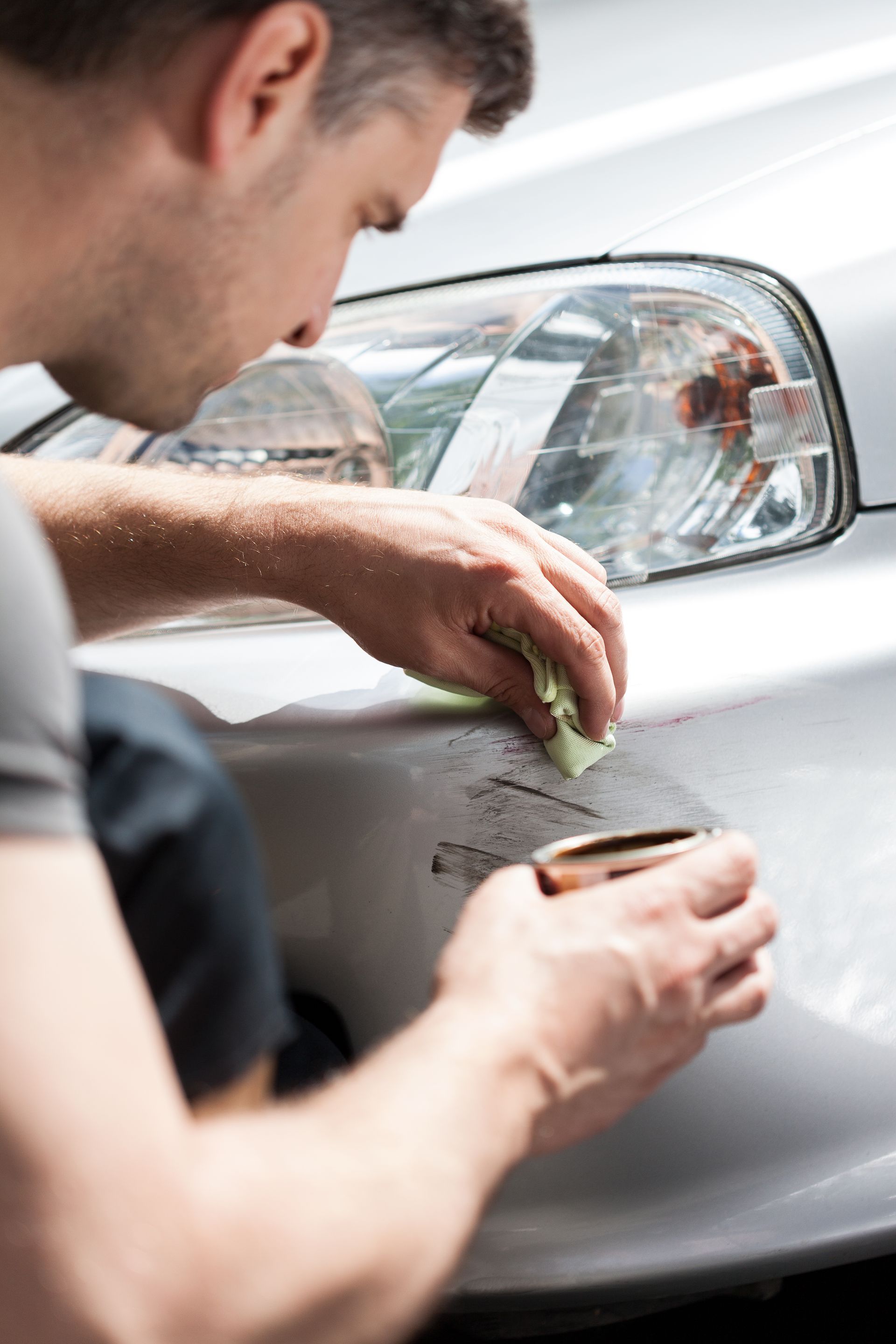 a man is cleaning a car with a cloth .