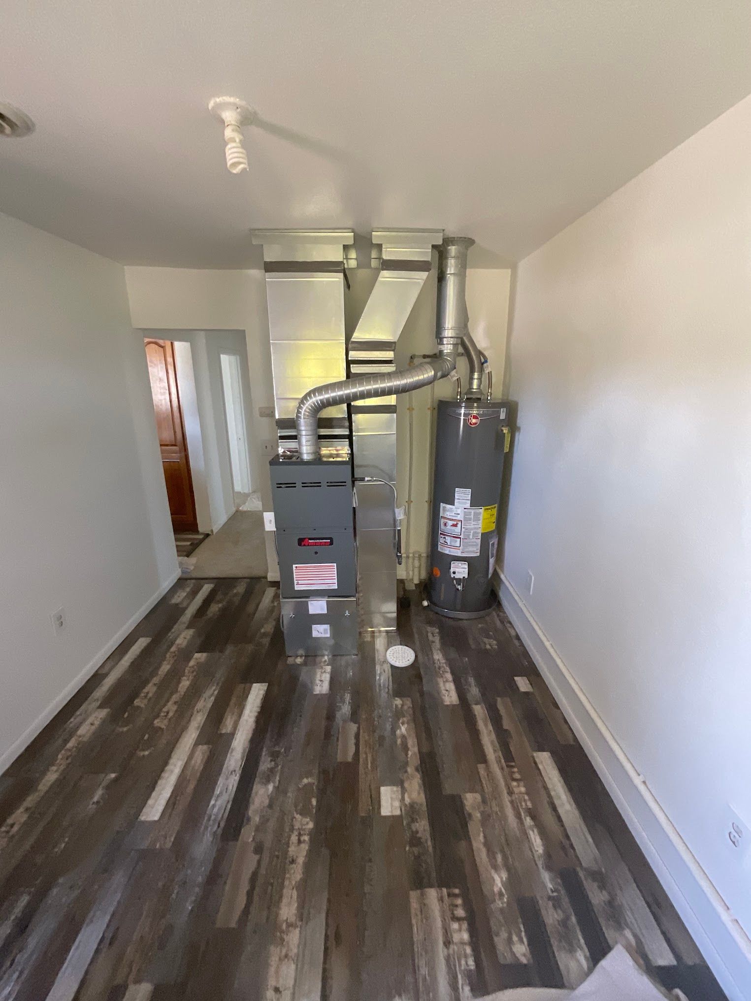 A room with a furnace and a water heater in it.