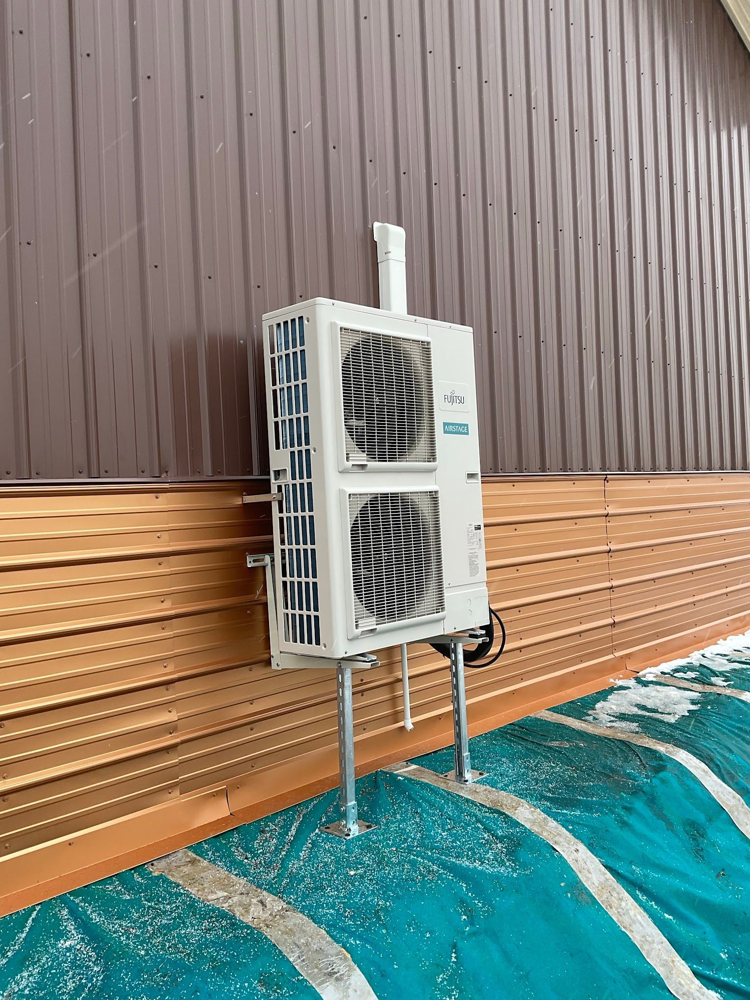 A large air conditioner is mounted on the side of a building.