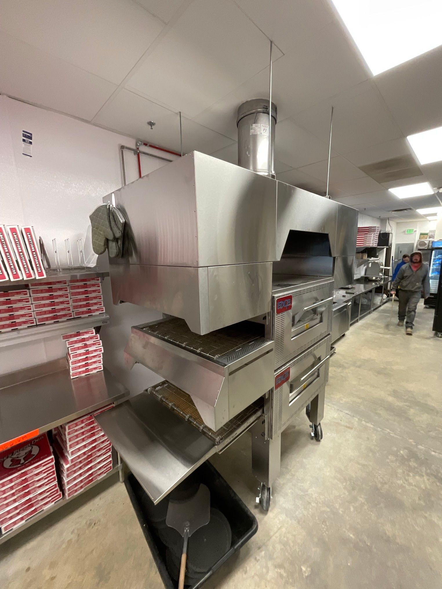 A pizza oven is sitting in the middle of a room in a restaurant.