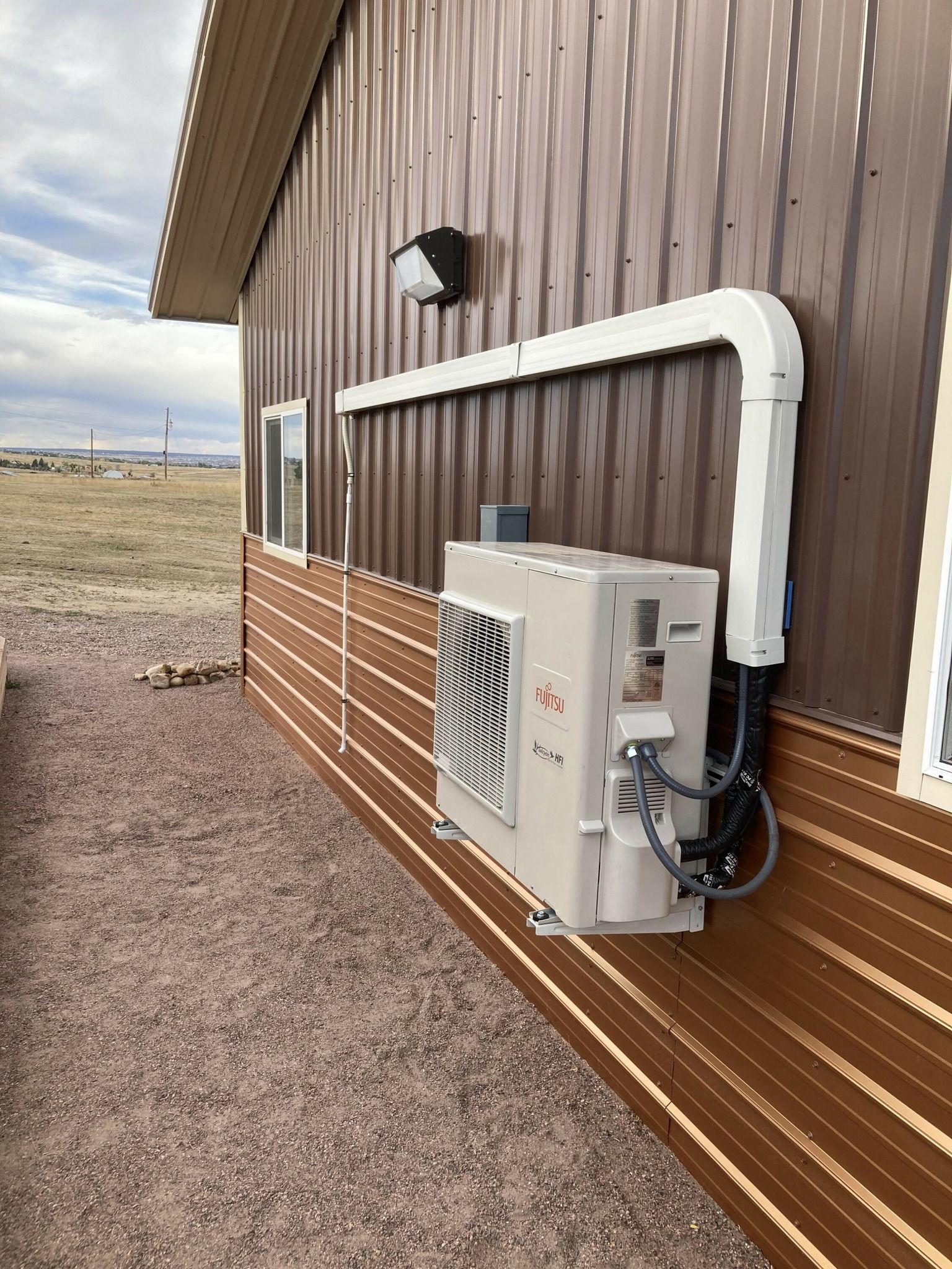 A large air conditioner is mounted on the side of a building.