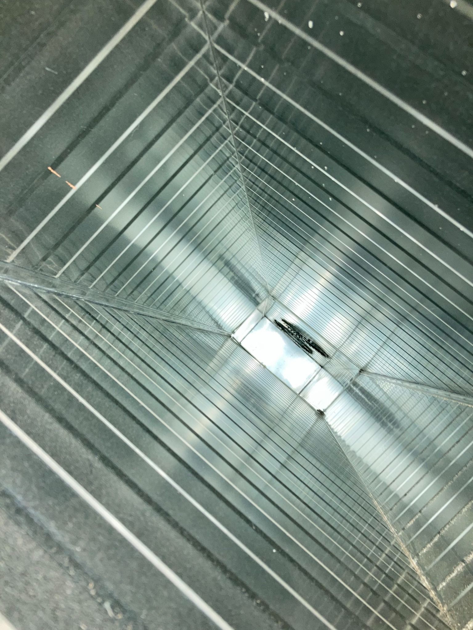 A close up of a metal duct with a hole in it