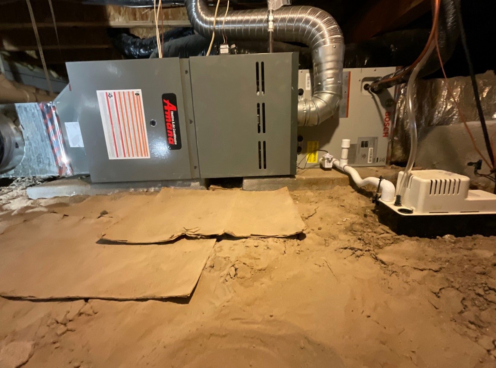 An air conditioner is sitting in the corner of a basement.