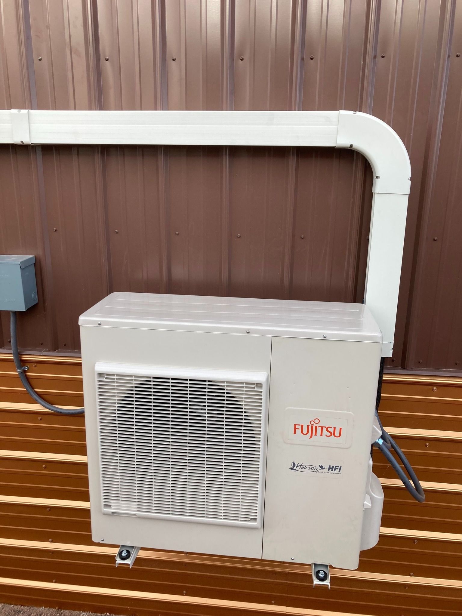 A fujitsu air conditioner is mounted on the side of a building.