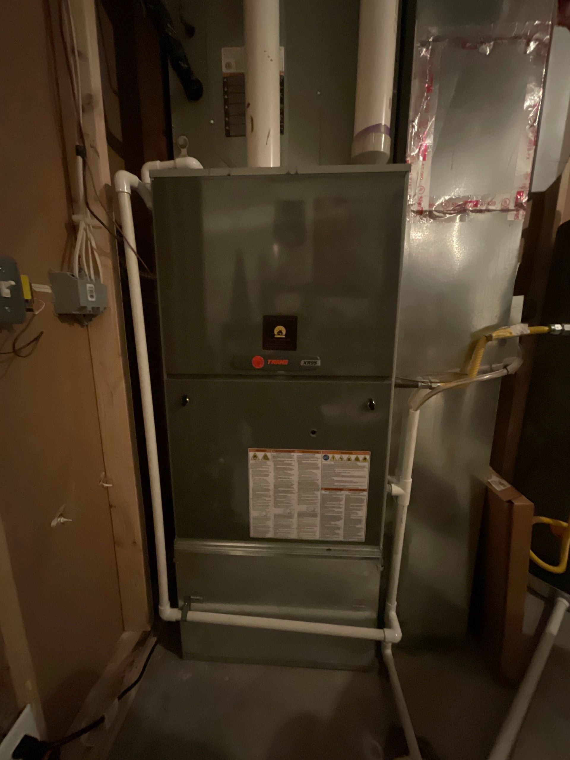 A furnace is sitting in a room next to a wall.