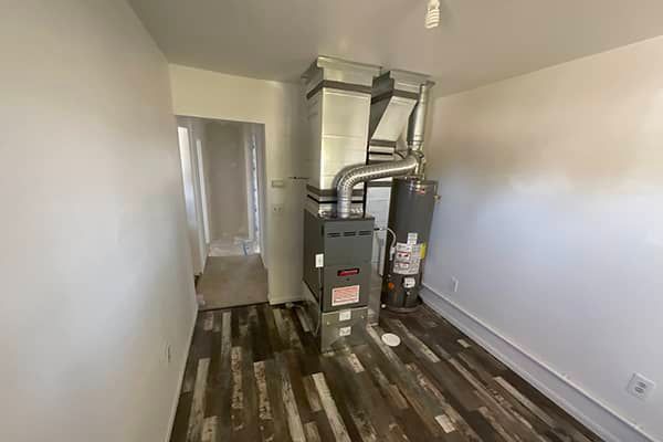 A room with a furnace and a water heater in it.