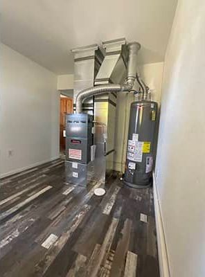 A room with a furnace and a water heater in it.