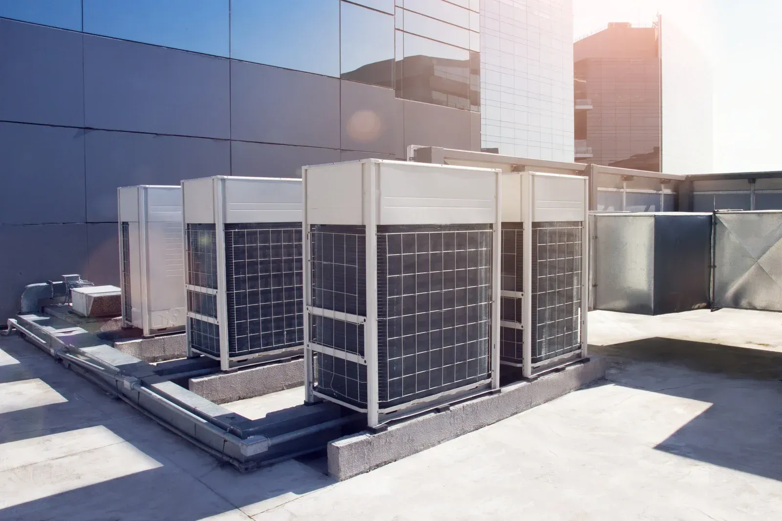 A row of air conditioners on the roof of a building.