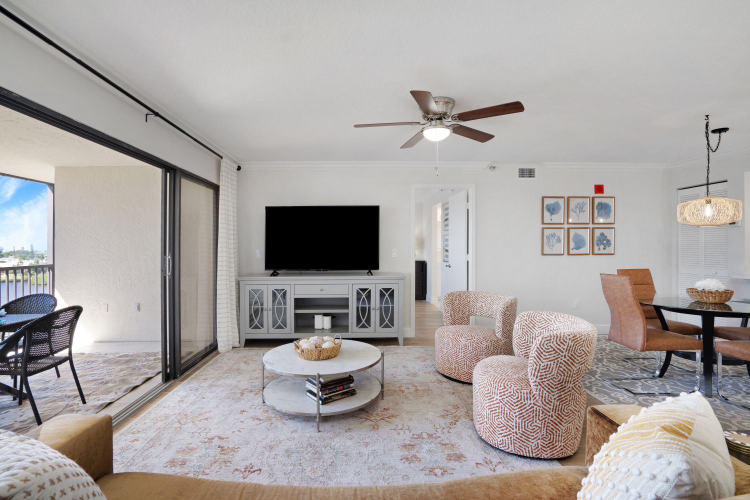 A living room with a couch , chairs , table and television.