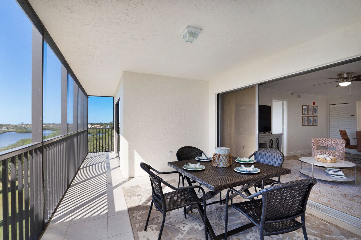 A balcony with a table and chairs and a view of a lake.