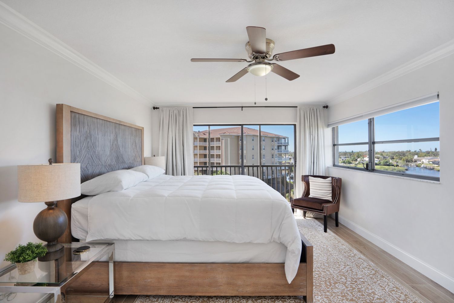 A bedroom with a large bed and a ceiling fan.