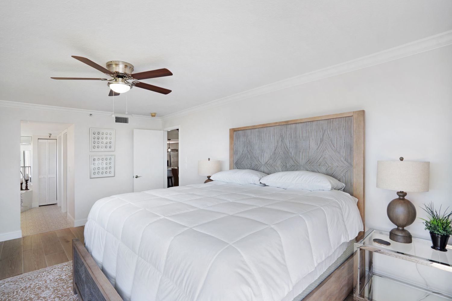 A bedroom with a large bed and a ceiling fan.