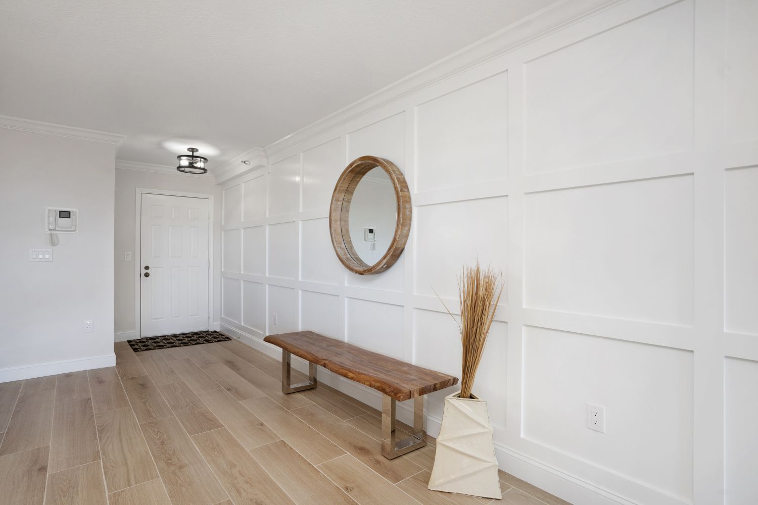 There is a bench and a mirror in the hallway.