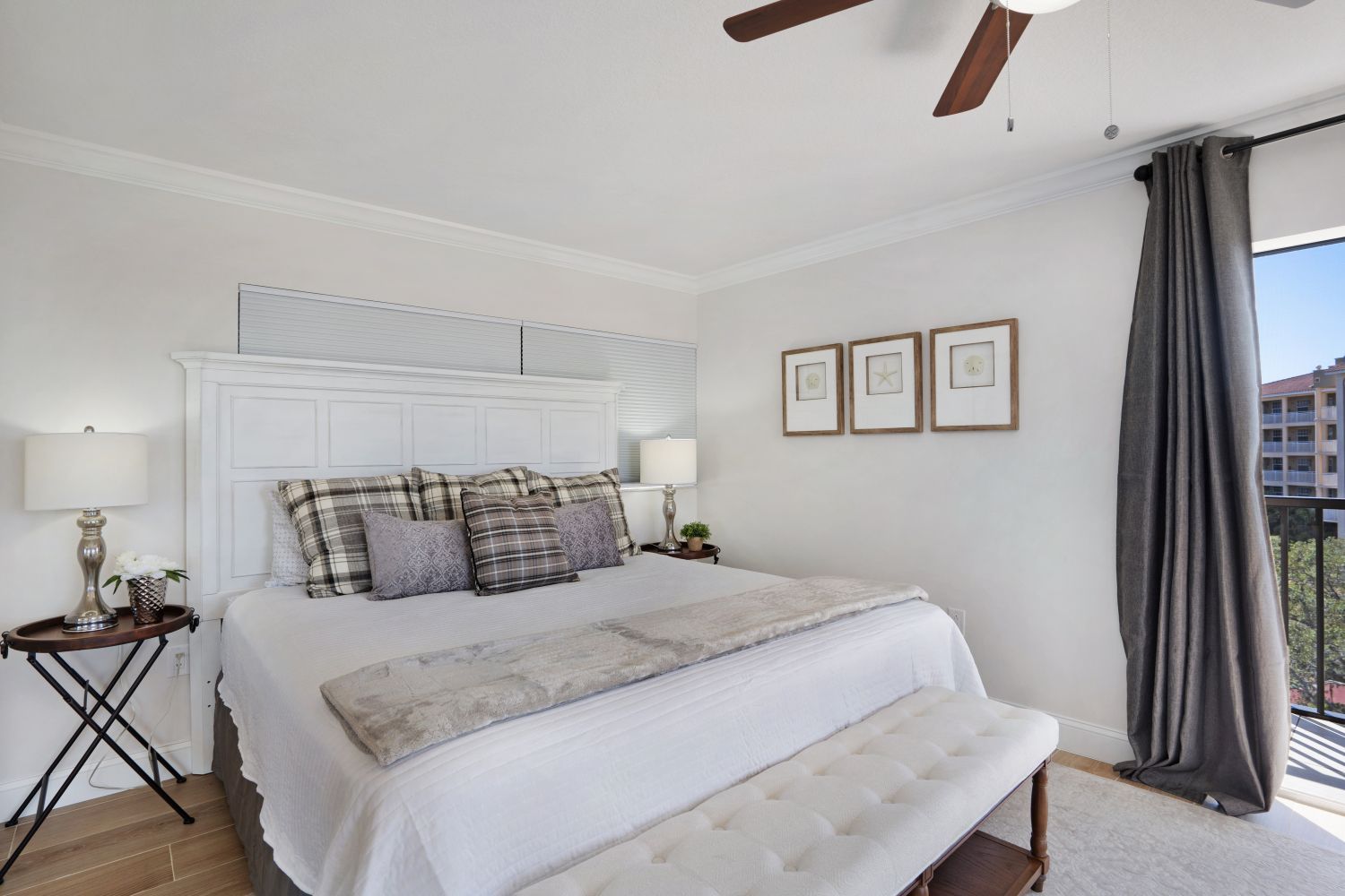 A bedroom with a king size bed and a ceiling fan.