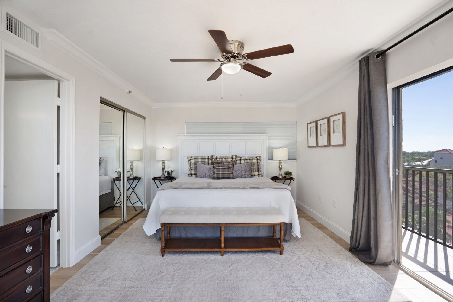 A bedroom with a large bed and a ceiling fan