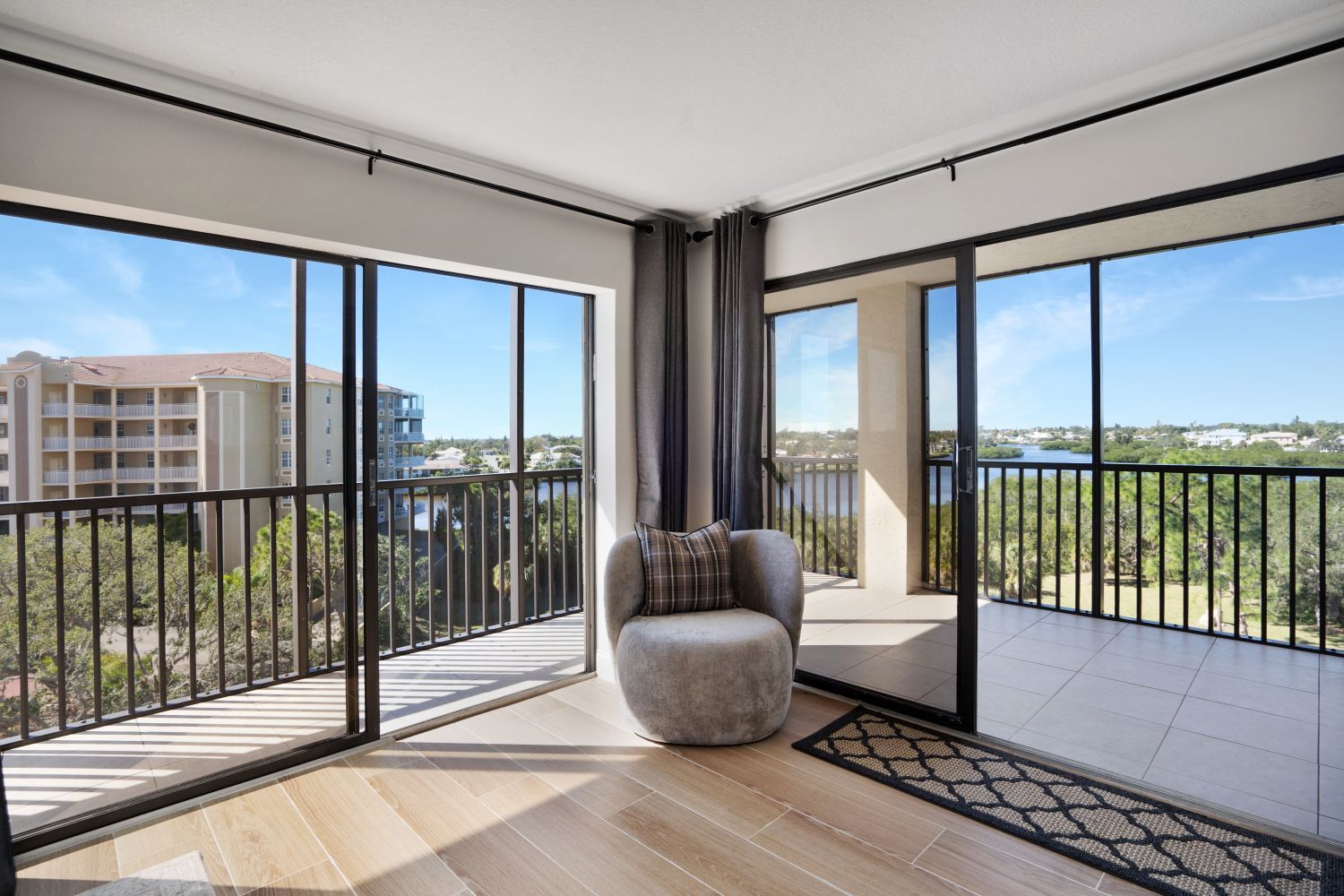 There is a chair in the middle of the room with a balcony.