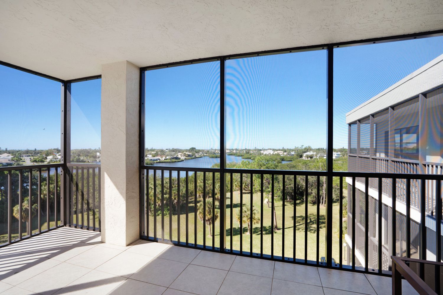 A balcony with a view of a river and trees