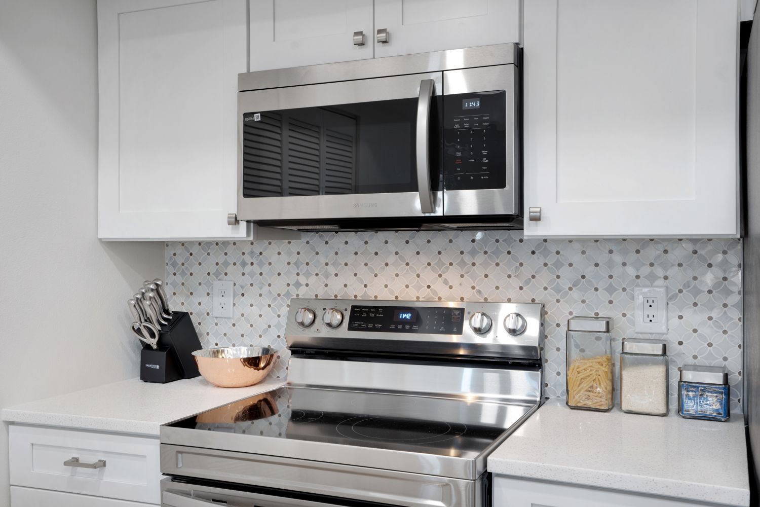 A kitchen with stainless steel appliances and white cabinets