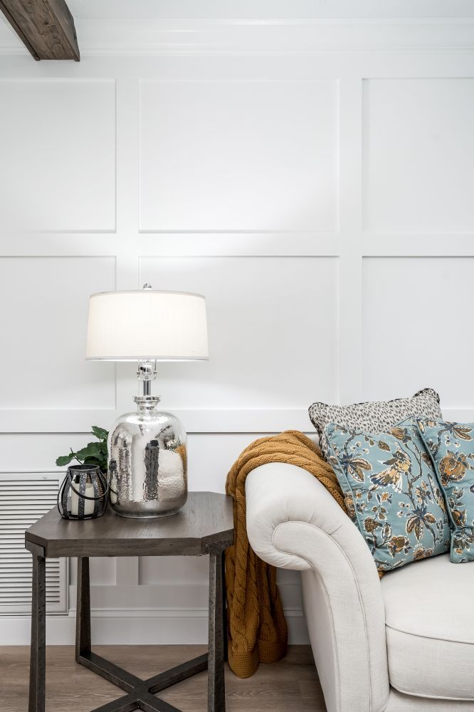 A living room with a couch , table and lamp.